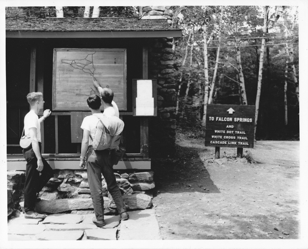 A group of young men prepare for the Monadnock climb, reviewing the old map on the front of the Warden's Cabin (now known as the Park Office) at Monadnock State Park Headquarters.