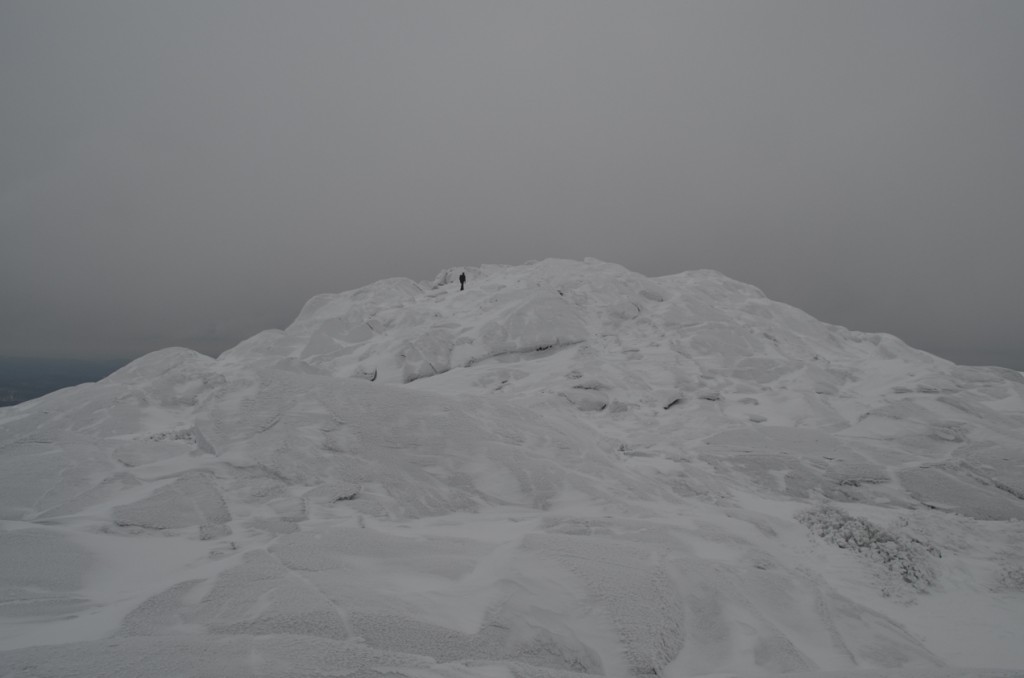 A lone hiker reaches the summit of Monadnock viewed from the Pumpelly Trail. 02.26.13. Photo by Patrick Hummel