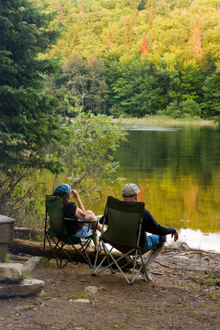 A couple enjoys the view from a waterfront campsite at Lake Francis State Park in Pittsburg, New Hampshire.
