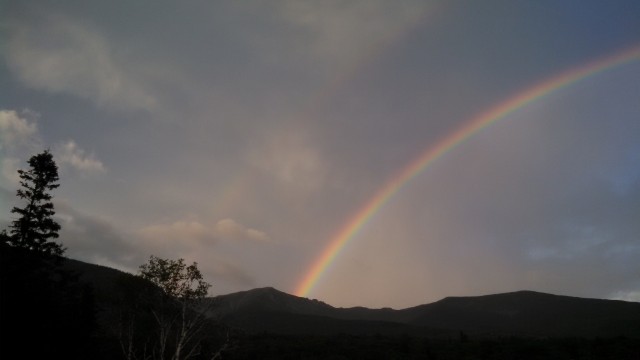 A rainbow emerging from the summit of Mt. Lafayette