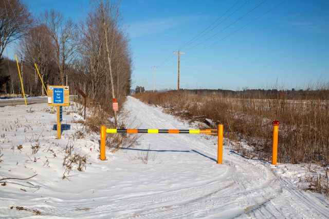 After a short walk up River Road, you'll see this orange gate where the Northern Rail Trail begins.