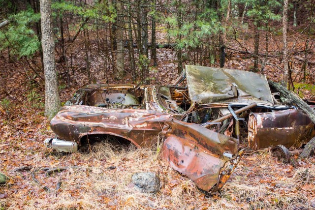 Old, wrecked automobile on the shore of Parker Pond