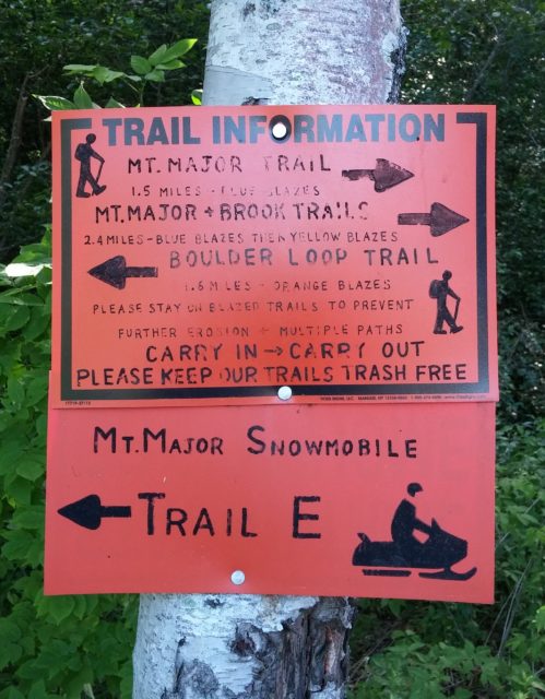 One of a few different trail signs located in the parking lot.