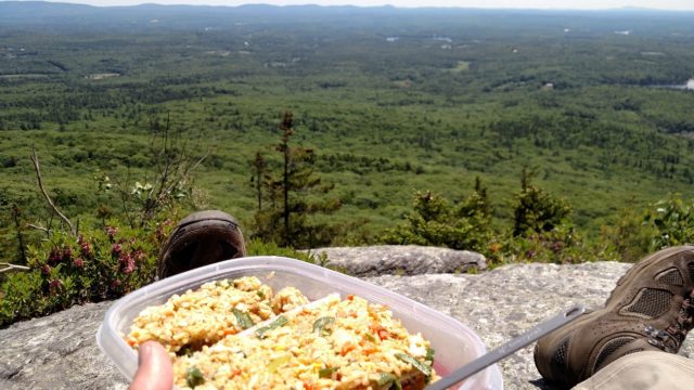 View from on top of Mount Monadnock with tupperware of food in the lower third of the shot